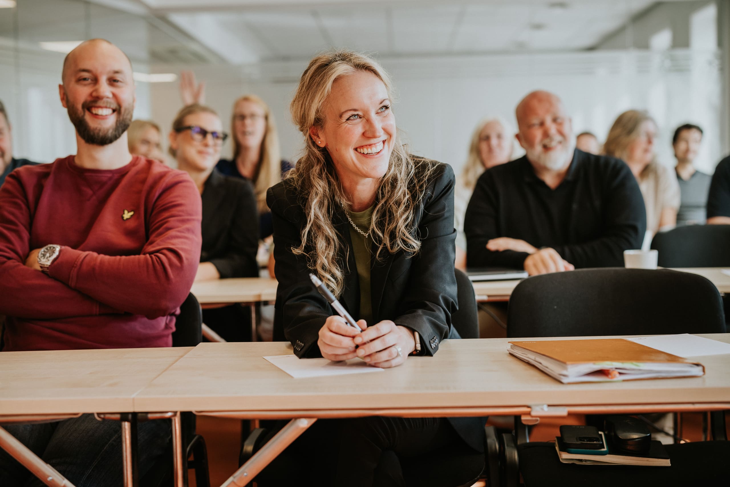 Bild av ett klassrum med två personse som ler längst fram